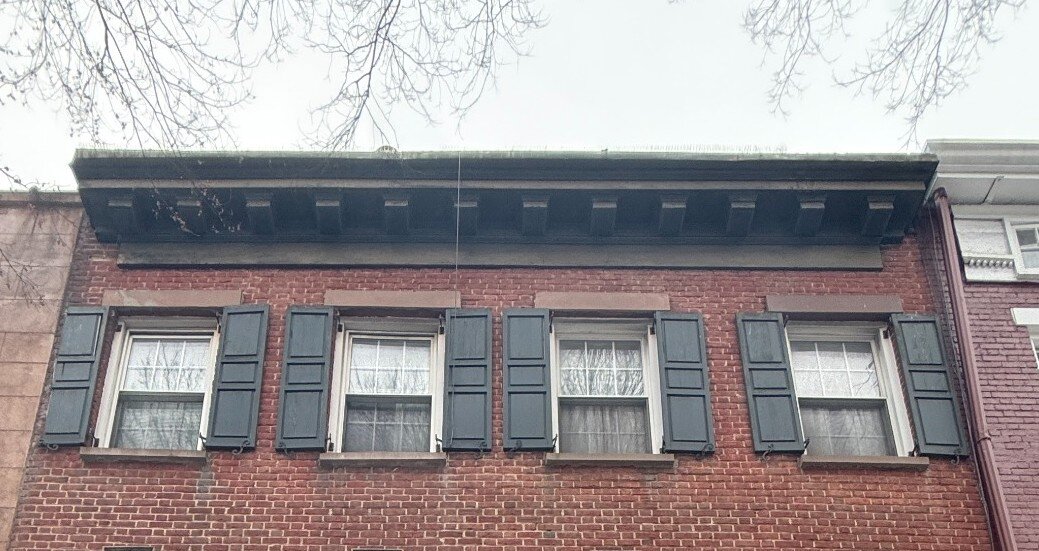 Continuous cornice line across both addresses